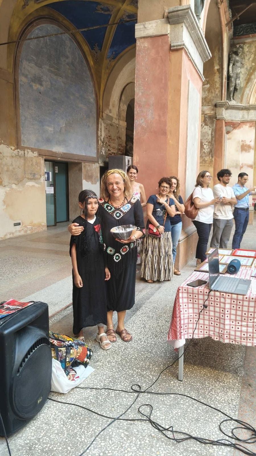Una bambina premiata insieme a una volontaria dell'associazione, davanti al pubblico