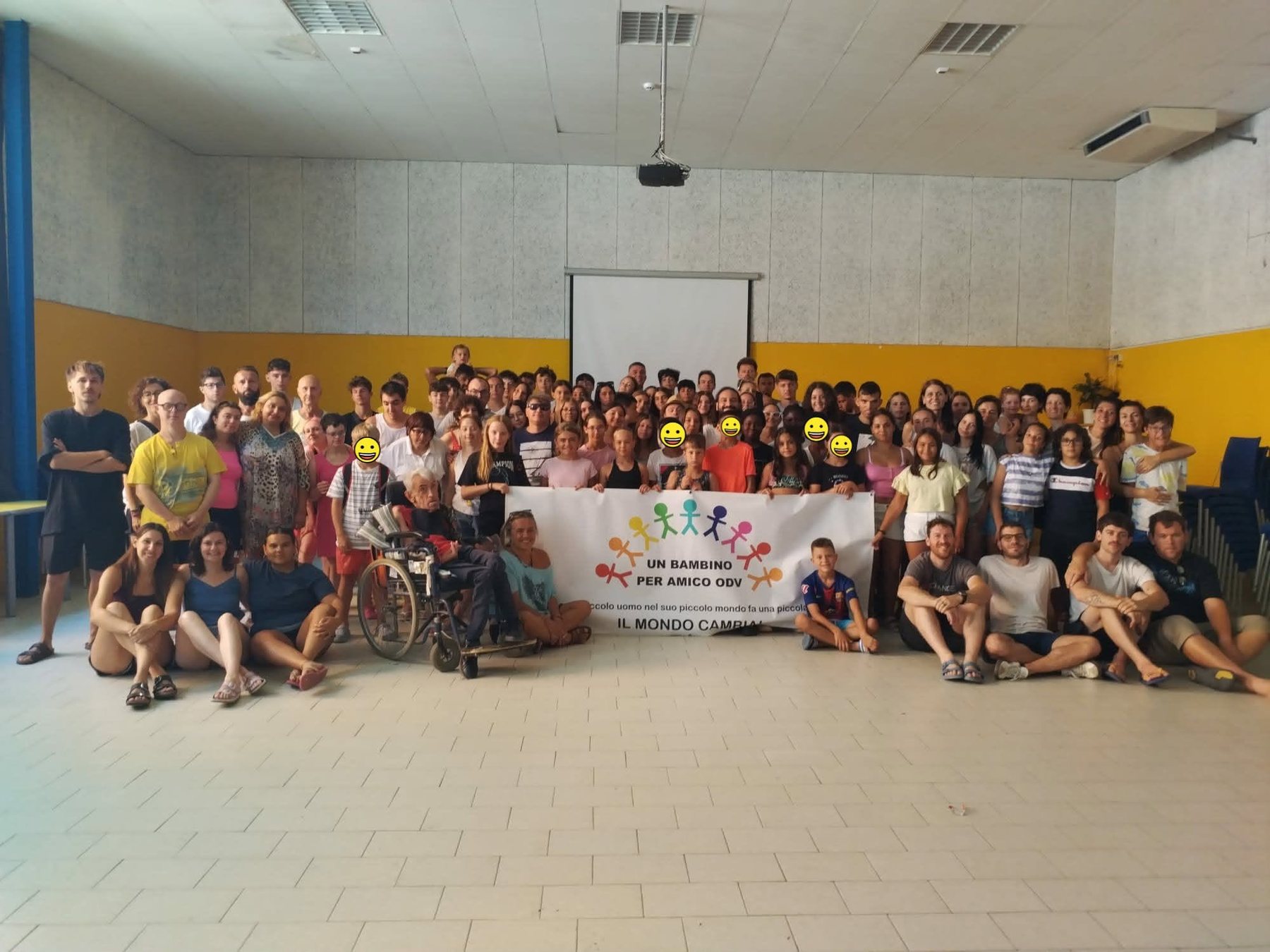Il grande gruppo del Campo Estivo 2026 di Un bambino per amico ODV, con lo striscione dell'associazione