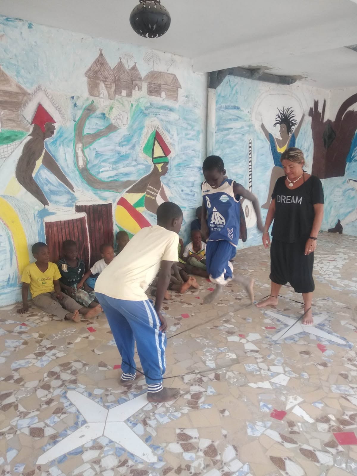 Bambini giocano insieme a una volontaria durante il viaggio in Senegal del gennaio 2025
