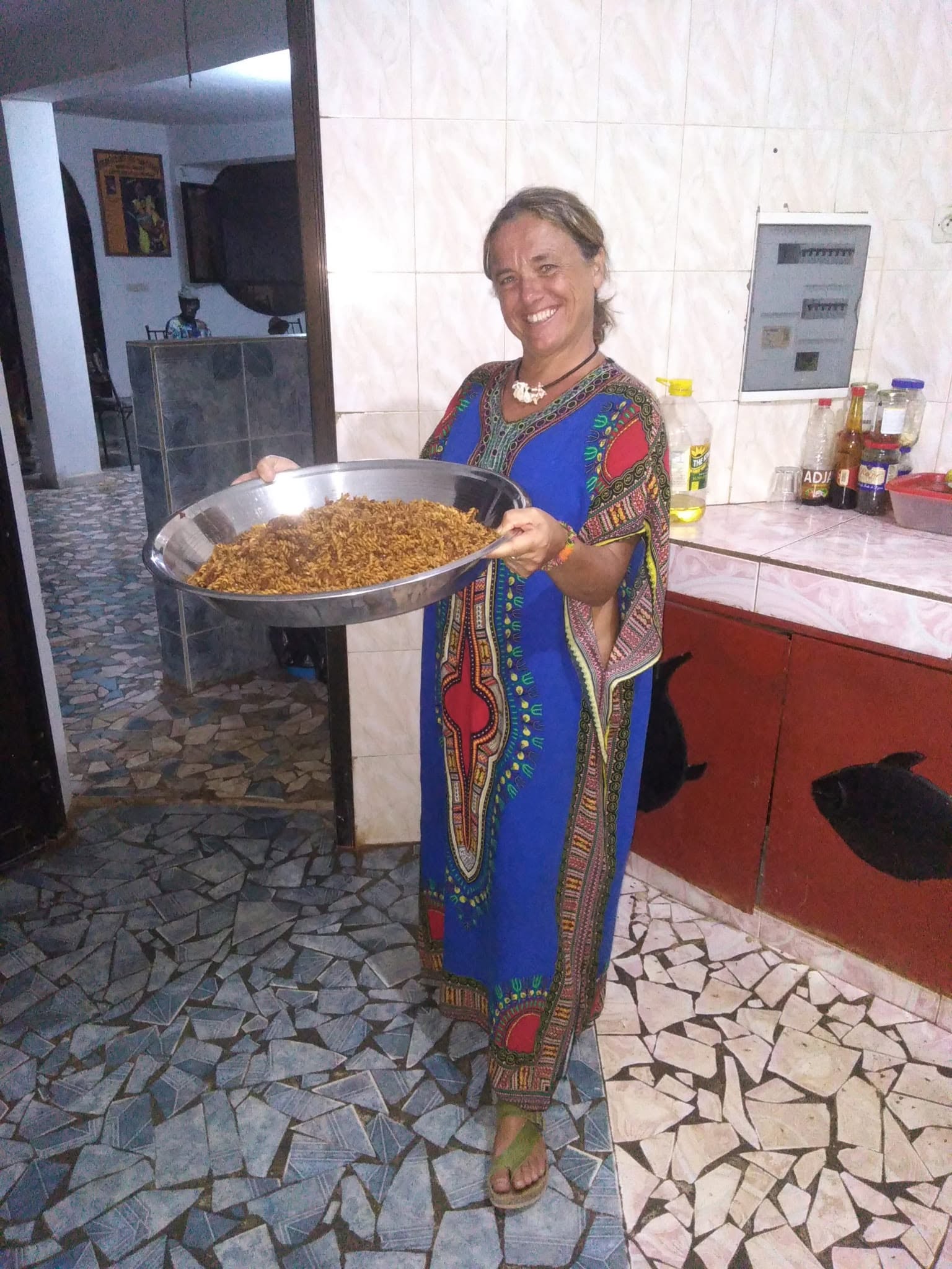 Una partecipante al viaggio mostra un grande vassoio di cibo preparato in Senegal