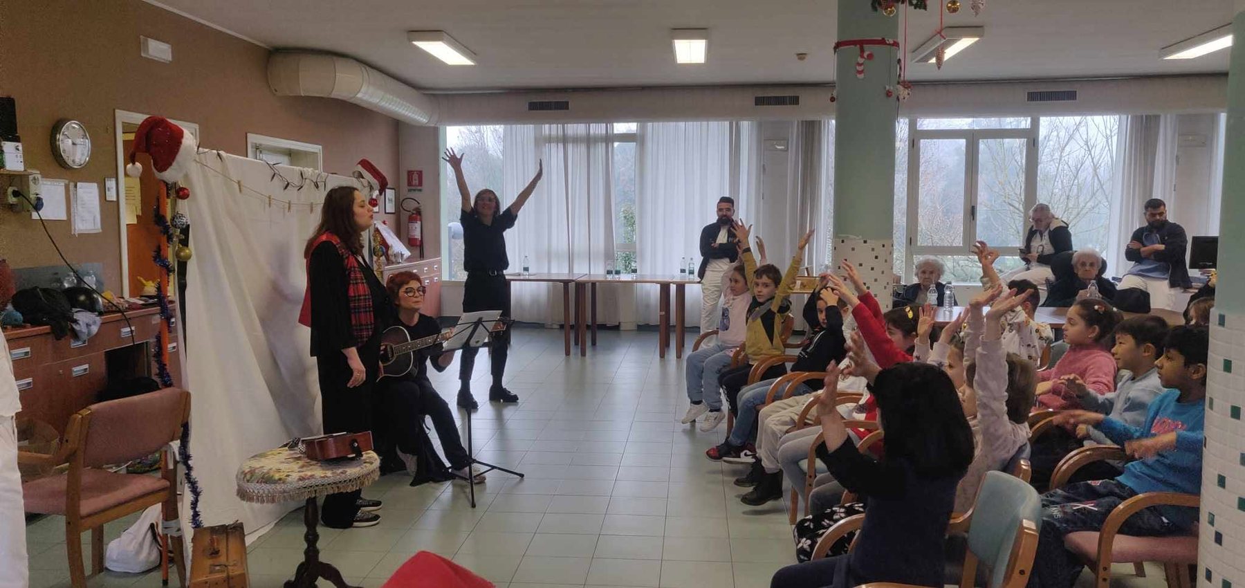 Bambini, anziani e volontari partecipano a un racconto teatrale nella casa di riposo